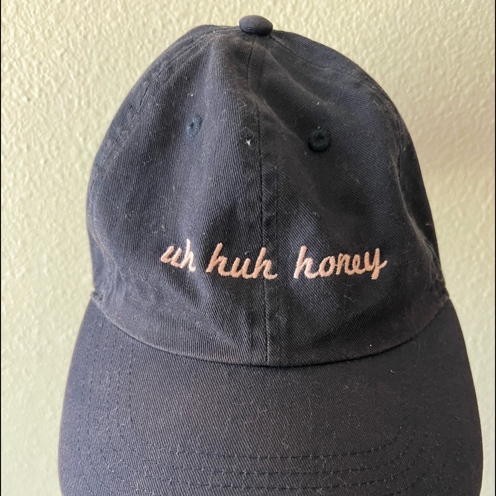 Navy blue baseball cap with peach writing “uh huh honey”. One size fits all.
